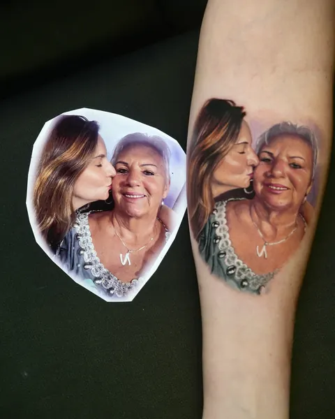 Printed photo of a grandmother and granddaughter next to the same scene tattooed on the forearm.